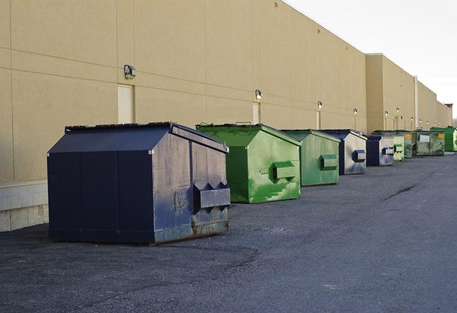 a construction worker empties a wheelbarrow of waste into the dumpster in Gilroy CA